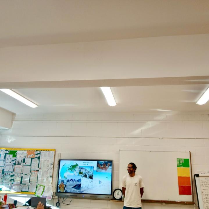 Photo of Milad Rajaei presenting in front of a screen at a Primary school classroom
